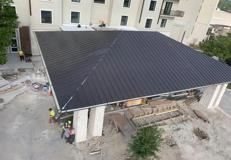 Metal roofing installation team working on a commercial building in Henryetta